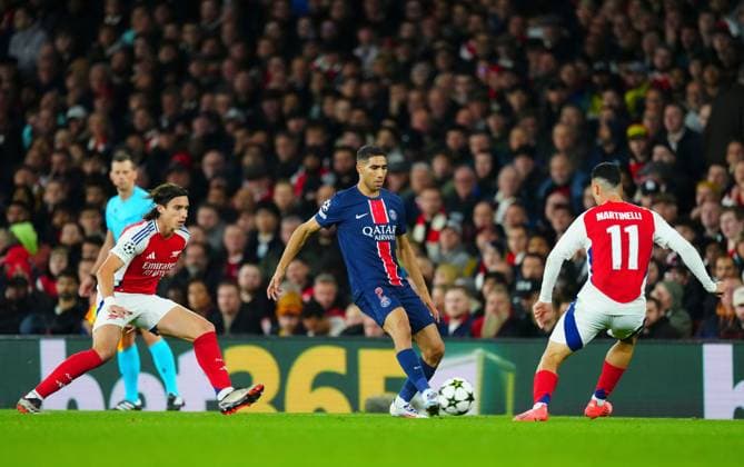 Achraf Hakimi of PSG in between Riccardo Calafiori and Gabriel Martinelli of Arsenal Arsenal v Paris Saint-Germain, UEFA Champions League, Group Stage, Football, Emirates Stadium, London, UK, 01 Oct 2024 EDITORIAL USE ONLY No use with unauthorised audio, video, data, fixture lists, club league logos or live services. Online in-match use limited to 120 images, no video emulation. No use in betting, games or single club league player publications. Copyright: xJavierxGarcia Shutterstockx 14750159ac