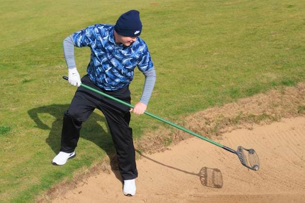 1st October 2024; Kingsbarns Golf Links, Fife, Scotland; Alfred Dunhill Links Golf Championship, Second Practice Day; Robert Macintyre of Scotland rakes a bunker on the 4th hole on Kingsbarns Golf Links, during a practice round ahead of the Dunhill Links Championship  ActionPlus12698758 DavidxYoung