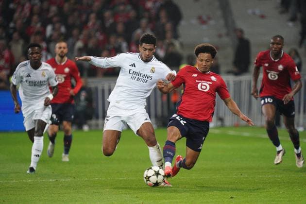 Jude Bellingham of Real Madrid =and Tiago Santos of Lille battle for the ball Lille v Real Madrid, UEFA Champions League, Group Stage, Football, Pierre Mauroy Stadium, Lille, France, 02 Oct 2024 EDITORIAL USE ONLY No use with unauthorised audio, video, data, fixture lists, club league logos or live services. Online in-match use limited to 120 images, no video emulation. No use in betting, games or single club league player publications. Copyright: xDavexWinter Shutterstockx 14750773ag
