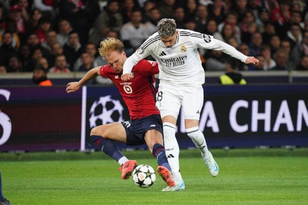 Federico Valverde of Real Madrid is tackled by Mitchel Bakker of Lille Lille v Real Madrid, UEFA Champions League, Group Stage, Football, Pierre Mauroy Stadium, Lille, France, 02 Oct 2024 EDITORIAL USE ONLY No use with unauthorised audio, video, data, fixture lists, club league logos or live services. Online in-match use limited to 120 images, no video emulation. No use in betting, games or single club league player publications. Copyright: xDavexWinter Shutterstockx 14750773at