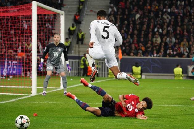 Jude Bellingham of Real Madrid is tackled by Tiago Santos of Lille Lille v Real Madrid, UEFA Champions League, Group Stage, Football, Pierre Mauroy Stadium, Lille, France, 02 Oct 2024 EDITORIAL USE ONLY No use with unauthorised audio, video, data, fixture lists, club league logos or live services. Online in-match use limited to 120 images, no video emulation. No use in betting, games or single club league player publications. Copyright: xDavexWinter Shutterstockx 14750773bw
