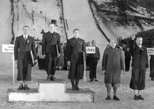GERMANY GARMISCH-PARTENKIRCHEN 1936-02-16. Three male ski jumpers during the award ceremony at the 1936 Winter Olympics. Seen here from left are silver medalist Sven Eriksson, Sweden, gold medalist Birger Ruud, Norway, and bronze medalist Reidar Andersen, Norway. On the podium stand Henri Baillet-Latour, Belgian baron, president of the IOC 1925-1942, and Karl Ritter von Halt, sports official, German member of the IOC. Garmisch-Partenkirchen Germany OS sp_sw x5600x *** GERMANY GARMISCH PARTENKIRCHEN 1936 02 16 Three male ski jumpers during the award ceremony at the 1936 Winter Olympics Seen here from left are silver medalist Sven Eriksson, Sweden, gold medalist Birger Ruud, Norway, and bronze medalist Reidar Andersen, Norway On the podium stand Henri Baillet Latour, Belgian baron, president of the IOC 1925 1942, and Karl Ritter von Halt, sports official, German member of the IOC Garmisch Partenkirchen Germany OS sp sw x5600x  Copyright: xWeltbild SVTx 1936 WINTER OLYMPICS