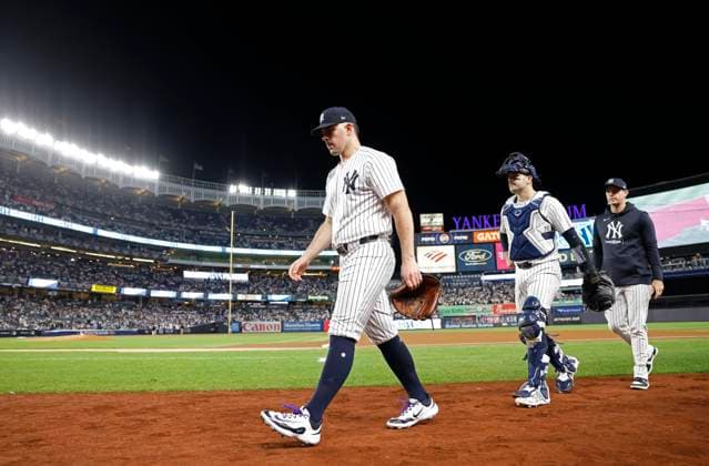 New York Yankees starting pitcher Carlos Rodon walks onto the field with catcher Austin Wells and manager Aaron Boone before the start of game two of the MLB, Baseball Herren, USA ALDS against the Kansas City Royals at Yankee Stadium in New York City on Monday, October 7, 2024.  NYP20241007801 JOHNxANGELILLO