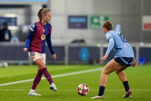 9th October 2024; Joie Stadium, Manchester, England; UEFA Womens Champions League Football, Manchester City versus Barcelona; Caroline Graham Hansen of Barcelona women passes the ball under pressure from Kerstin Casparij of Manchester City  ActionPlus12702088 StevenxFlynn