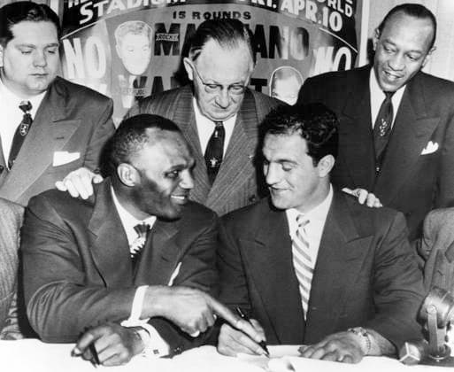 USA CHICAGO 02 25 1953. Final paperwork is being arranged here between American boxers Jersey Joe Walcott (seated TV) and Rocky Marciano for a rematch for the heavyweight crown, set to take place in Chicago on April 10th. The gentlemen behind are from left Lou Radzienda, Livingston Osborn, chairman of the Illinois Boxing Commission and Jesse Owens, running star of yesterday. Chicago USA sp_sw x5600x *** USA CHICAGO 02 25 1953 Final paperwork is being arranged here between American boxers Jersey Joe Walcott seated TV and Rocky Marciano for a rematch for the heavyweight crown, set to take place in Chicago on April 10th The gentlemen behind are from left Lou Radzienda, Livingston Osborn, chairman of the Illinois Boxing Commission and Jesse Owens, running star of yesterday Chicago USA sp sw x5600x  Copyright: xInternationalxNewsxPhotos SVTx WALCOTT AND MARCIANO WRITE DEAL