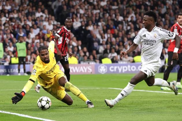 Madrid, Spain, 5th November 2024. Vinicius Junior of Real Madrid looks on as Mike Maignan of AC Milan guides the ball out of play during the UEFA Champions League match at the Santiago Bernabau, Madrid. Picture credit should read: Jonathan Moscrop Sportimage EDITORIAL USE ONLY. No use with unauthorised audio, video, data, fixture lists, club league logos or live services. Online in-match use limited to 120 images, no video emulation. No use in betting, games or single club league player publications. SPI-3425-0057