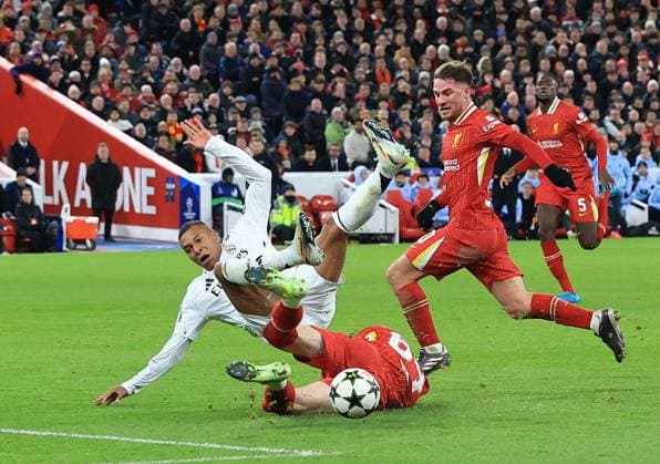 27th November 2024; Anfield, Liverpool, Merseyside, England; Champions League Football, Liverpool versus Real Madrid; Conor Bradley of Liverpool wins the ball from Kylian Mbappe of Real Madrid with a sliding tackle  ActionPlus12720696 DavidxBlunsden