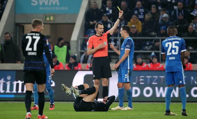 Referee Richard Hempel yellow card for Tobias Müller after foul on Derry Scherhant Sport Football Soccer 2 Bundesliga Men 14 Matchday Season 2024 2025 29 11 2024 1 FC Magdeburg FCM vs Hertha BSC Berlin DFL regulations prohibit any use of photographs as image sequences and or quasi video