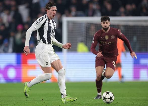 Turin, Italy, 11th December 2024. Dusan Vlahovic of Juventus passes the ball as Josko Gvardiol of Manchester City closes in during the UEFA Champions League match at Juventus Stadium, Turin. Picture credit should read: Jonathan Moscrop Sportimage EDITORIAL USE ONLY. No use with unauthorised audio, video, data, fixture lists, club league logos or live services. Online in-match use limited to 120 images, no video emulation. No use in betting, games or single club league player publications. SPI-3517-0062
