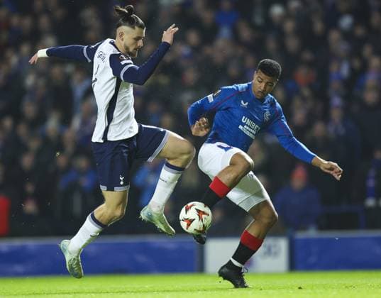 Hamza Igamane of Rangers in action with Radu Draguin of Tottenham Hotspur during the UEFA Europa League group phase match at Ibrox Stadium, Glasgow. Rangers v Tottenham Hotspur, UEFA Europa League, Football, Ibrox Stadium, Glasgow, Scotland, UK - 12 Dec 2024 EDITORIAL USE ONLY No use with unauthorised audio, video, data, fixture lists, club league logos or live services. Online in-match use limited to 120 images, no video emulation. No use in betting, games or single club league player publications.  Copyright: xLukexNickerson RangersxFC Shutterstockx 14998163c