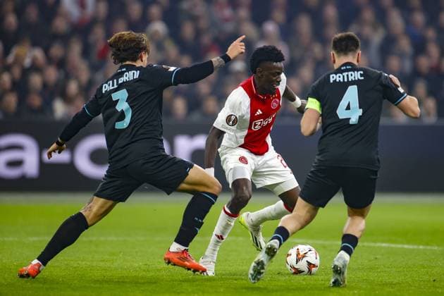 AMSTERDAM, 12-12-2024 , JohanCruyff Arena, Europa League Football, Ajax - Lazio Roma. Ajax player Bertrand Traore, Lazio Roma player Samuel Gigot, Lazio Roma player Patric Ajax - Lazio Roma  x27001851x Copyright: