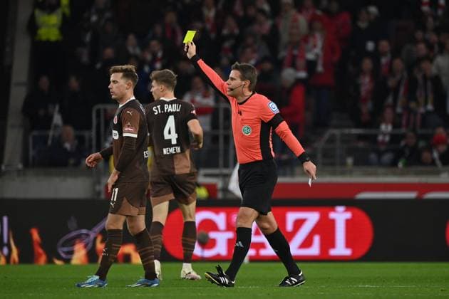 21 12 2024, xjrdrx, Soccer 1 Bundesliga, VfB Stuttgart FC St Pauli emspor, v l Johannes Eggestein FC St Pauli David Nemeth FC St Pauli Referee Referee Felix Brych shows the yellow card DFL DFB REGULATIONS PROHIBIT ANY USE OF PHOTOGRAPHS as IMAGE SEQUENCES and or QUASI VIDEO Stuttgart