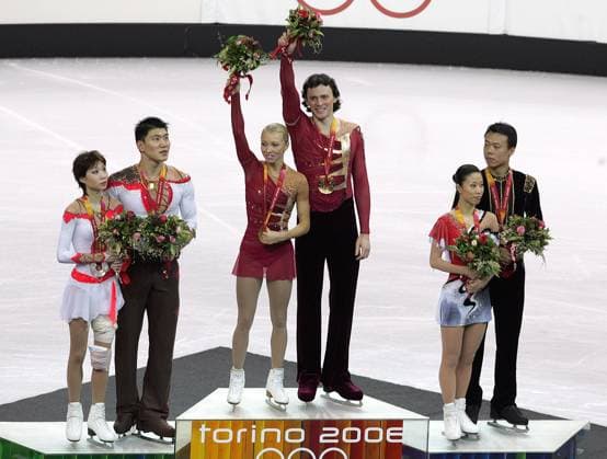 Tatiana Totmianina and Maxim Marinin (center) with their gold medal during the 2006 Winter Olympics Figure skating, Eiskunstlauf Pairs short program Monday, February 13, 2006 at Palavela in Turin, Italy. Dan Zhang and Hao Zhang (left) took silver and Xeu Shen and Hongbo Zhao won bronze. Dan Zhang s knee is bandaged due to a fall during her performance. (Barbara Johnston Philadelphia Inquirer KRT) Turin ITA EDITORIAL USE ONLY Copyright: xx BarbaraxL.xJohnstonx krtphotos314284