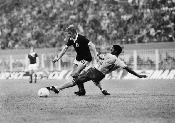 Football - 1974 World Cup - First Round, Group Two: Scotland 2 Zaire 0 Scotland s Denis Law evades a tackle from Zaire s Buanga Tshimen at Westfalenstadion, Dortmund, West Germany. 