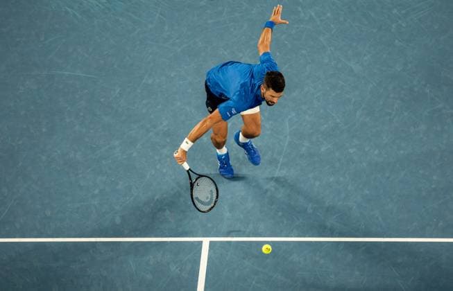 (250122) -- MELBOURNE, Jan. 22, 2025 -- Novak Djokovic hits a return during the men s singles quarterfinal between Novak Djokovic of Serbia and Carlos Alcaraz of Spain at Australian Open tennis tournament in Melbourne, Australia, Jan. 21, 2025. (Photo by Xinhua) (SP)AUSTRALIA-MELBOURNE-TENNIS-AUSTRALIAN OPEN-DAY 10 HuxJingchen 