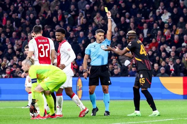 2025-01-30 AFC Ajax v Galatasaray - UEFA Europa League 2024 25 League Phase MD8 AMSTERDAM, NETHERLANDS - JANUARY 30: Referee Jesus Gil Manzano shows a yellow card to Victor Osimhen of Galatasaray AS (wearing protective face-mask) during the UEFA Europa League 2024 25 League Phase MD8 match between AFC Ajax and Galatasaray at Johan Cruijff ArenA on January 30, 2025 in Amsterdam, Netherlands. Amsterdam Johan Cruijff ArenA Netherlands Content not available for redistribution in The Netherlands directly or indirectly through any third parties. Copyright: xBenxGalx