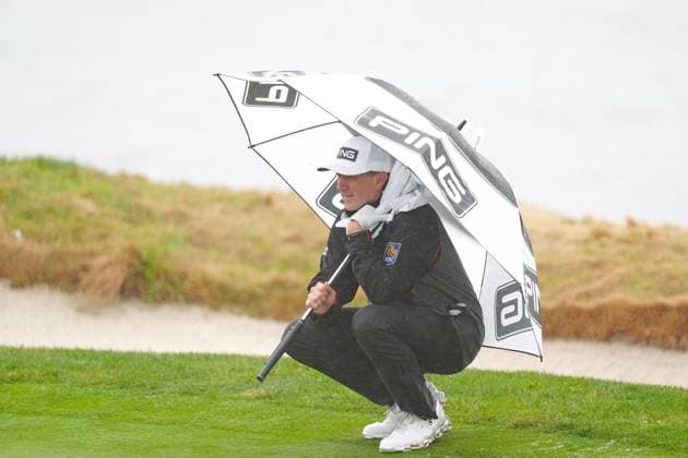 PEBBLE BEACH, CA - FEBRUARY 01: PGA, Golf Herren golfer Mackenzie Hughes waits to putt under an umbrella on the 17th hole during the third round of the AT&T Pebble Beach Pro AM on February 1, 2025, at Pebble Beach Golf Links in Pebble Beach, California. (Photo by Brian Spurlock Icon Sportswire) GOLF: FEB 01 PGA AT&T Pebble Beach Pro-Am EDITORIAL USE ONLY Icon25020153