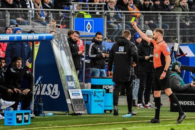 Referee Michael Bacher shows the bench or athletics coach Jan Hasenkamp HSV not in the picture the yellow card Germany , Hamburg , Volksparkstadion , Football , 2 Bundesliga , Hamburger SV Hannover 96