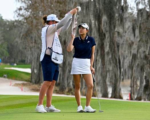 A Caddy tries to protect Rose Zhang from the rain as they approach the 18th green at the LPGA, Golf Damen Hilton Grand Vacations Tournament of Champions at the Lake Nona Golf and Country Club in Orlando, Florida on Sunday February 2, 2025. .  ORP20250202026 JOExMARINO