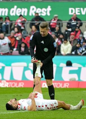 09 02 2025, xjpx, Soccer 2 Bundesliga, 1 FC Koeln FC Schalke 04 v l Referee Tobias Welz as physiotherapist He helps Jusuf Gazibegovic Koeln , who has a cramp DFL DFB REGULATIONS PROHIBIT ANY USE OF PHOTOGRAPHS as IMAGE SEQUENCES and or QUASI VIDEO Koeln