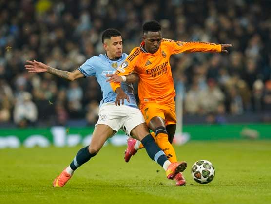 Manchester, England, 11th February 2025. Manchester City s Savinho with Real Madrid™s Vinicius Junior during the UEFA Champions League match at the Etihad Stadium, Manchester. Picture credit should read: Andrew Yates Sportimage EDITORIAL USE ONLY. No use with unauthorised audio, video, data, fixture lists, club league logos or live services. Online in-match use limited to 120 images, no video emulation. No use in betting, games or single club league player publications. SPI_AY_036_Man_City_Real_Madrid SPI-3675-0073