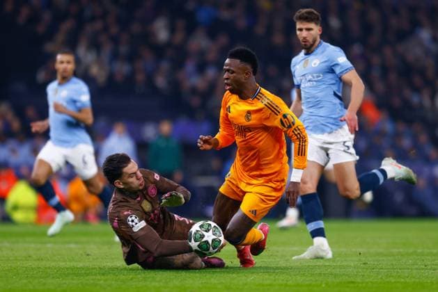 February 11, 2025, Manchester, Manchester, ENGLAND: Vinicius Junior of Real Madrid and Ederson of Manchester City in action during the UEFA Champions League 2024 25 League Knockout Play-off First Leg match between Manchester City and Real Madrid at Manchester City Stadium on February 11, 2025, in Manchester, England. Manchester ENGLAND - ZUMAa181 20250211_zaa_a181_128 Copyright: xDennisxAgyemanx