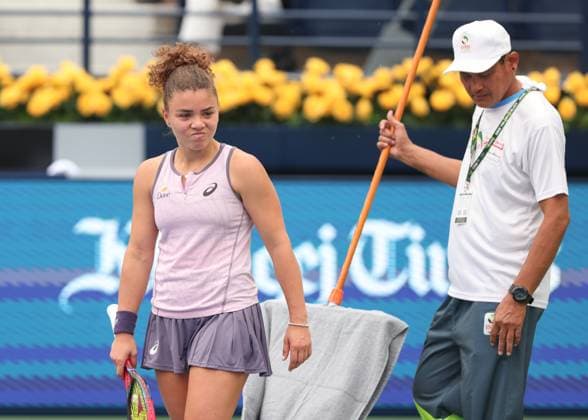 Jasmine Paolini stands next to a tournament staff member and looks skeptically at the rain-soaked court, Dubai Duty Free Tennis Championships, Dubai, U A E Copyright: xJuergenxHasenkopfx