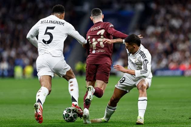 Phil Foden of Manchester City under pressure from Jude Bellingham of Real Madrid and Dani Ceballos of Real Madrid Real Madrid v Manchester City, UEFA Champions League, Knockout Round Play-offs, Second Leg, Football, Santiago BernaboÆ?Ã?Æ?o Ã? u, Madrid, Spain - 19 Feb 2025 EDITORIAL USE ONLY No use with unauthorised audio, video, data, fixture lists, club league logos or live services. Online in-match use limited to 120 images, no video emulation. No use in betting, games or single club league player publications. Copyright: xRubenxAlbarran Shutterstockx 15137179aa