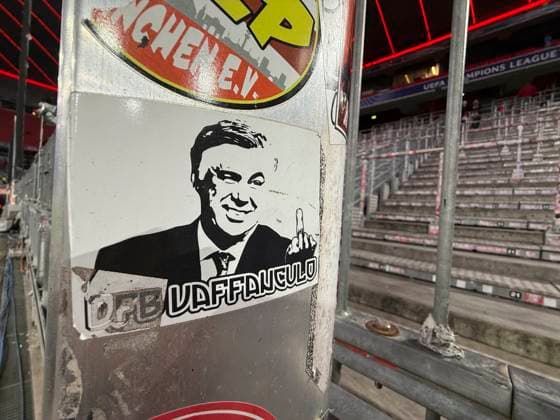 18 02 2025, Football UEFA Championsleague 2024 2025 Play off second leg, FC Bayern Munich Celtic Glasgow, in the Allianz Arena Munich In the still empty Ultra Curve there is a sticker with the likeness of Madrids coach Carlo Ancelotti ITA , an ex Bayern coach, on the picture with a stinky finger and Italian slander greeting to the DFB Vaffangulo