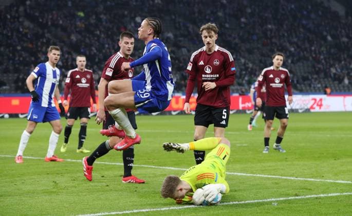 Derry Scherhant jumps over goalkeeper Jan Reichert duel match scene action sport soccer soccer DFL 2 Bundesliga men 23 matchday season 2024 2025 21 02 2025 Hertha BSC Berlin vs 1 FC Nürnberg FCN DFL regulations prohibit any use of photographs as image sequences and or quasi video