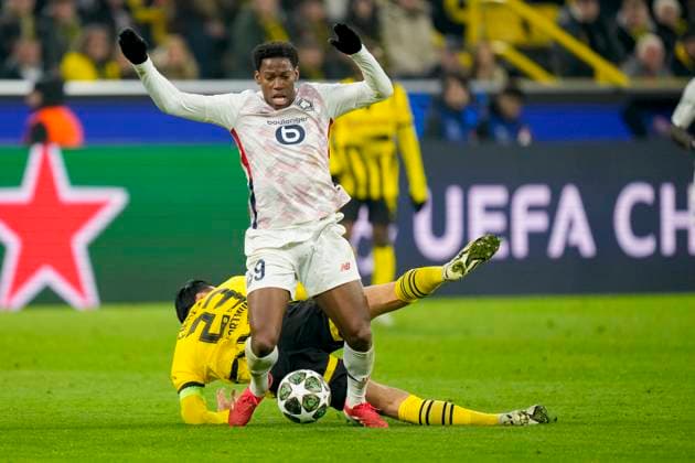 Emre Can Borussia Dortmund and Jonathan David LOSC Lille battle for the ball during the UEFA Champions League 2024 25 Round of 16 First Leg match between Borussia Dortmund and LOSC Lille at Signal Iduna Park on March 4, 2025 in Dortmund, Germany