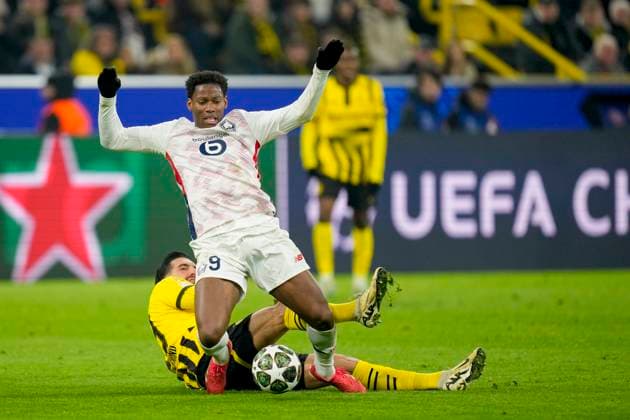 Emre Can Borussia Dortmund and Jonathan David LOSC Lille battle for the ball during the UEFA Champions League 2024 25 Round of 16 First Leg match between Borussia Dortmund and LOSC Lille at Signal Iduna Park on March 4, 2025 in Dortmund, Germany