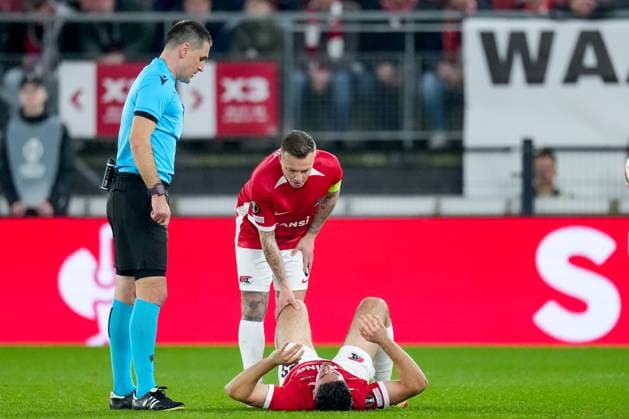 2025-03-06 AZ Alkmaar v Tottenham - UEFA Europa League 2024 25 Round of 16 First Leg ALKMAAR, NETHERLANDS - MARCH 6: Referee Rade Obrenovic and Jordy Clasie of AZ Alkmaar check on Mayckel Lahdo of AZ Alkmaar during the UEFA Europa League 2024 25 Round of 16 First Leg match between AZ Alkmaar and Tottenham at AFAS Stadion on March 6, 2025 in Alkmaar, Netherlands. Alkmaar AFAS Stadion Netherlands Content not available for redistribution in The Netherlands directly or indirectly through any third parties. Copyright: xEdxvanxdexPolx