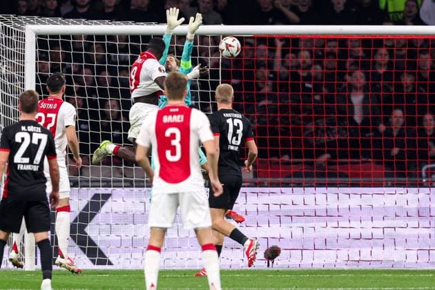 2025-03-06 AFC Ajax v Eintracht Frankfurt - UEFA Europa League 2024 25 Round of 16 First Leg AMSTERDAM, NETHERLANDS - MARCH 6: Brian Brobbey of AFC Ajax heads the ball and scores a goal, goalkeeper Kevin Trapp of Eintracht Frankfurt deflecting during to the UEFA Europa League 2024 25 Round of 16 First Leg match between AFC Ajax and Eintracht Frankfurt at Johan Cruijff ArenA on March 6, 2025 in Amsterdam, Netherlands. Amsterdam Johan Cruijff ArenA Netherlands Content not available for redistribution in The Netherlands directly or indirectly through any third parties. Copyright: xBenxGalx