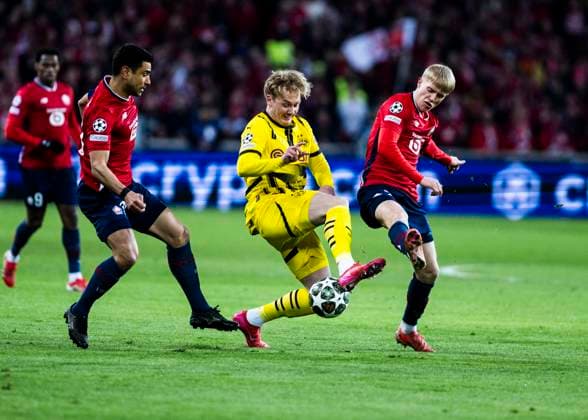 Lille, Stade Pierre Mauroy, 12 03 2025 Julian Brandt of Dortmund challenge Hakon Haraldsson during the match of the Championsleague Round 16 between Lille OSC v Borussia Dortmund