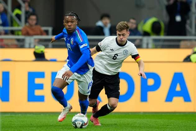 Destiny Udogie (Italy) and Joshua Kimmich (Germany) battle for the ball, UEFA Nations League Quarterfinal First leg, Italy and Germany, San Siro Stadium, March 20, 2025, Milan, Italy.
