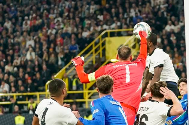 Goalkeeper Gianluigi Donnarumma Italy zund Jonathan Tah Germany battle for the ball during the UEFA Nations League Quarterfinal Leg Two match between Germany and Italy at Football Stadium Dortmund on March 23, 2025 in Dortmund, Germany