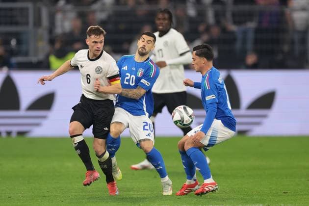 Dortmund, Germany, 23rd March 2025. Giacomo Raspadori of Italy looks on as team mate Mattia Zaccagni clashes with Joshua Kimmich of Germany during the UEFA Nations League match Germany vs Italy at BVB Stadion, Dortmund. Picture credit should read: Jonathan Moscrop Sportimage EDITORIAL USE ONLY. No use with unauthorised audio, video, data, fixture lists, club league logos or live services. Online in-match use limited to 120 images, no video emulation. No use in betting, games or single club league player publications. SPI_075_JM_GERMANY_ITALY_UNL_ SPI-3750-0075