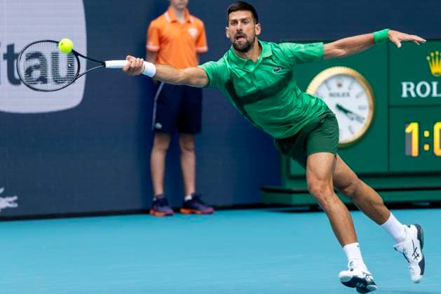 Novak Djokovic from Serbia stretches for a forehand shot to Grigor Dimitrov from Bulgaria in the first mens semifinal match on the stadium court at the Miami Open in the Hard Rock Stadium in Miami Gardens, Florida, on Friday, March 28, 2025. Djokovic defeated Dimitrov 6-2,6-3.  MIA20250328117 GARYxIxROTHSTEIN