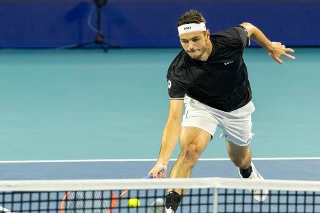 Taylor Fritz from the USA hits a forehand shot at the net to Jakub Mensik from Czech Republic in the second mens semifinal match on the stadium court at the Miami Open in the Hard Rock Stadium in Miami Gardens, Florida, on Friday, March 28, 2025. Fritz defeated Mensik  MIA20250328203 GARYxIxROTHSTEIN
