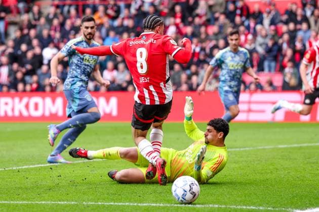 2025-03-30 PSV v AFC Ajax - Dutch Eredivisie EINDHOVEN, NETHERLANDS - MARCH 30: Sergino Dest of PSV battles for possession with Goalkeeper Matheus of AFC Ajax during the Dutch Eredivisie match between PSV and AFC Ajax at Philips Stadion on March 30, 2025 in Eindhoven, Netherlands. Eindhoven Philips Stadion Netherlands Content not available for redistribution in The Netherlands directly or indirectly through any third parties. Copyright: xPieterxvanxderxWoudex