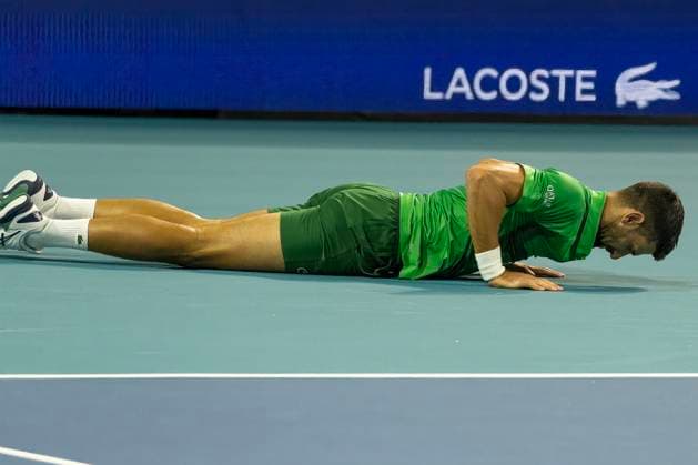 Novak Djokovic from Serbia slipped and fell on the court during a return shot to Jakub Mensik from the Czachia in the men s championship match on the stadium court at the Miami Open in the Hard Rock Stadium in Miami Gardens, Florida, on Sunday, March 30, 2025. Mensik defeated Djokovic 7-6 (4), 7-6(4).  MIA20250330116 GARYxIxROTHSTEIN