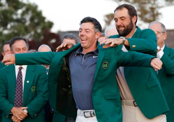 2024 Masters champion Scottie Scheffler holds the traditional green jacket for Rory McIlroy of Northern Ireland after McIlroy won the 2025 Masters golf tournament at Augusta National Golf Club in Augusta, Georgia, on Sunday, April 13, 2025. McIlroy defeated Justin Rose of England in a playoff and becomes the 6th person to complete the career grand slam.  AUG20250413682 JOHNxANGELILLO