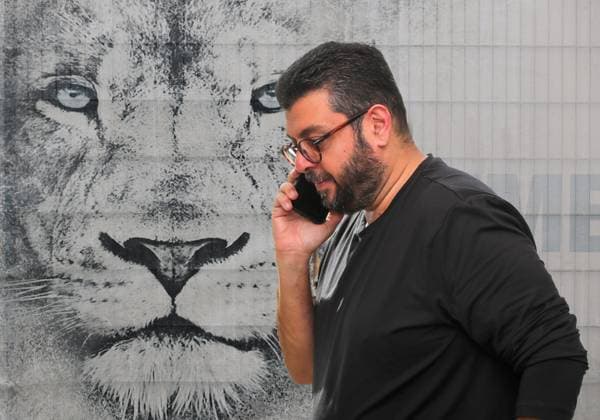 ATTENTION PHOTO MONTAGE Here in the picture Hasan Ismaik with phone, on the phone with cell phone, who would allegedly be willing to sell his shares in TSV 1860 Munich if a buyer can be found in the background the lions head at the training ground