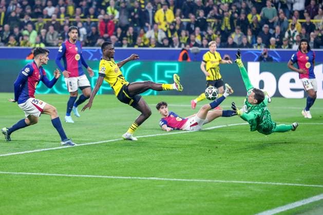 15 04 2025, Football, UEFA Champions League, Borussia Dortmund FC Barcelona, BVB Stadion, Quarter-final, Season 2024 2025 Serhou Guirassy BVB 9 shooting at goalkeeper Wojciech Szczesny FC Barcelona 25 Regulations prohibit any use of photographs as image sequences and or quasi video North Rhine-Westphalia Germany