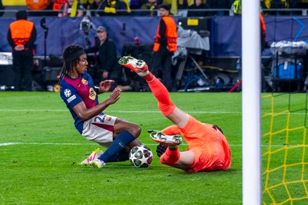 15 04 2025, Borussia Dortmund vs FC Barcelona, UEFA Champions League, quarter-final, second leg Barcelonas Jules Kounde l and Dortmunds goalkeeper Gregor Kobel fight for the ball Important note According to UEFA regulations, it is prohibited to use or have used photographs taken in the stadium and or of the match in the form of sequential images and or video-like photo series Copyright: xDavidxInderliedx