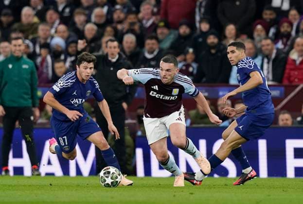 Birmingham, England, 15th April 2025. Aston Villa s John McGinn (c) evades Joao Neves of Paris St Germain (ll) and Achraf Hakimi of Paris St Germain (r) during the Aston Villa vs Paris Saint Germain Quarter Final 2nd Leg UEFA Champions League match at Villa Park, Birmingham. Picture credit should read: Andrew Yates Sportimage EDITORIAL USE ONLY. No use with unauthorised audio, video, data, fixture lists, club league logos or live services. Online in-match use limited to 120 images, no video emulation. No use in betting, games or single club league player publications. SPI_082_AY_Villa_PSG SPI-3842-0081