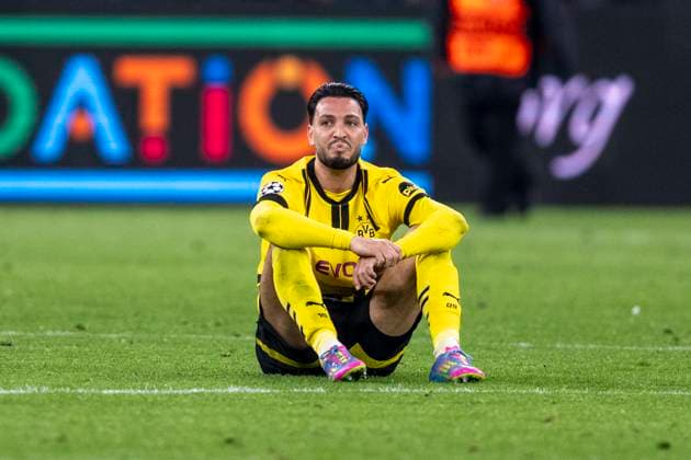 15 04 2025, Borussia Dortmund vs FC Barcelona, UEFA Champions League, quarter-final, second leg Dortmunds Ramy Bensebaini sits disappointed on the pitch Important note In accordance with UEFA regulations, it is prohibited to use or have used photographs taken in the stadium and or of the match in the form of sequential images and or video-like photo series Copyright: xDavidxInderliedx