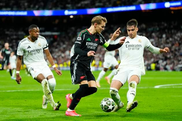 Real Madrid C.F. v Arsenal FC - UEFA Champions League 2024 25 Quarter Final Second Leg Martin Odegaard attacking midfield of Arsenal and Norway and Raul Asencio centre-back of Real Madrid and Spain during the UEFA Champions League 2024 25 Quarter Final Second Leg match between Real Madrid C.F. and Arsenal FC at Estadio Santiago Bernabeu on April 16, 2025 in Madrid, Spain. Madrid Spain  Copyright: xJosexBretonx originalFilename:bretonhernandez-realmadr250416_npYkV.jpg