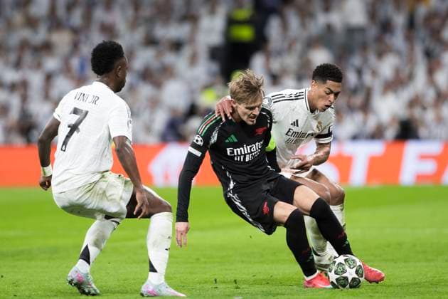 UEFA champions league - Real Madrid vs Arsenal MADRID, SPAIN - April 16: Martin Odegaard of Arsenal and Jude Bellingham of Real Madrid fight for the ball during the UEFA Champions League 2024 25 Quarter Final second Leg match between Real Madrid and Arsenal at Santiago Bernabeu Stadium. (Photo by Guillermo Martinez) Madrid Santiago Bernabeu Stadium Spain Copyright: xGuillermoxMartinezx